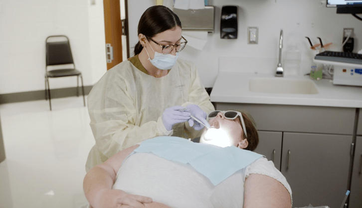 female dentist examining a female patient's mouth