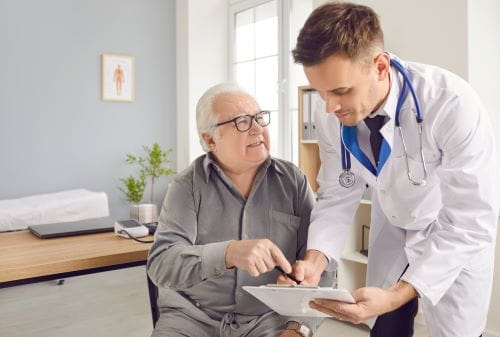 white elderly patient going over his medical plan with a male doctor
