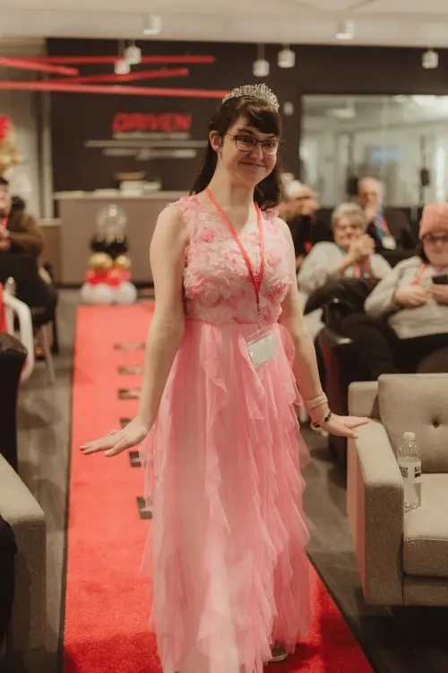 woman with disability in a pink floor length gown walking down the red carpet