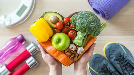 image of fruits and veggies with gym shoes and weights