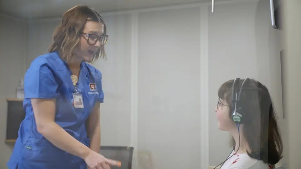 audiologist conducting a hearing test on a woman with an intellectual/developmental disability