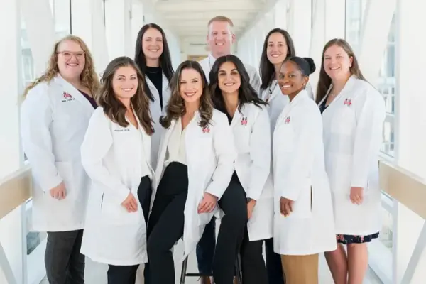 Nine fellows in white coats posing in the sky walk. 