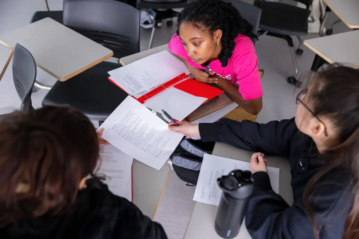 Students review a publication at a round table