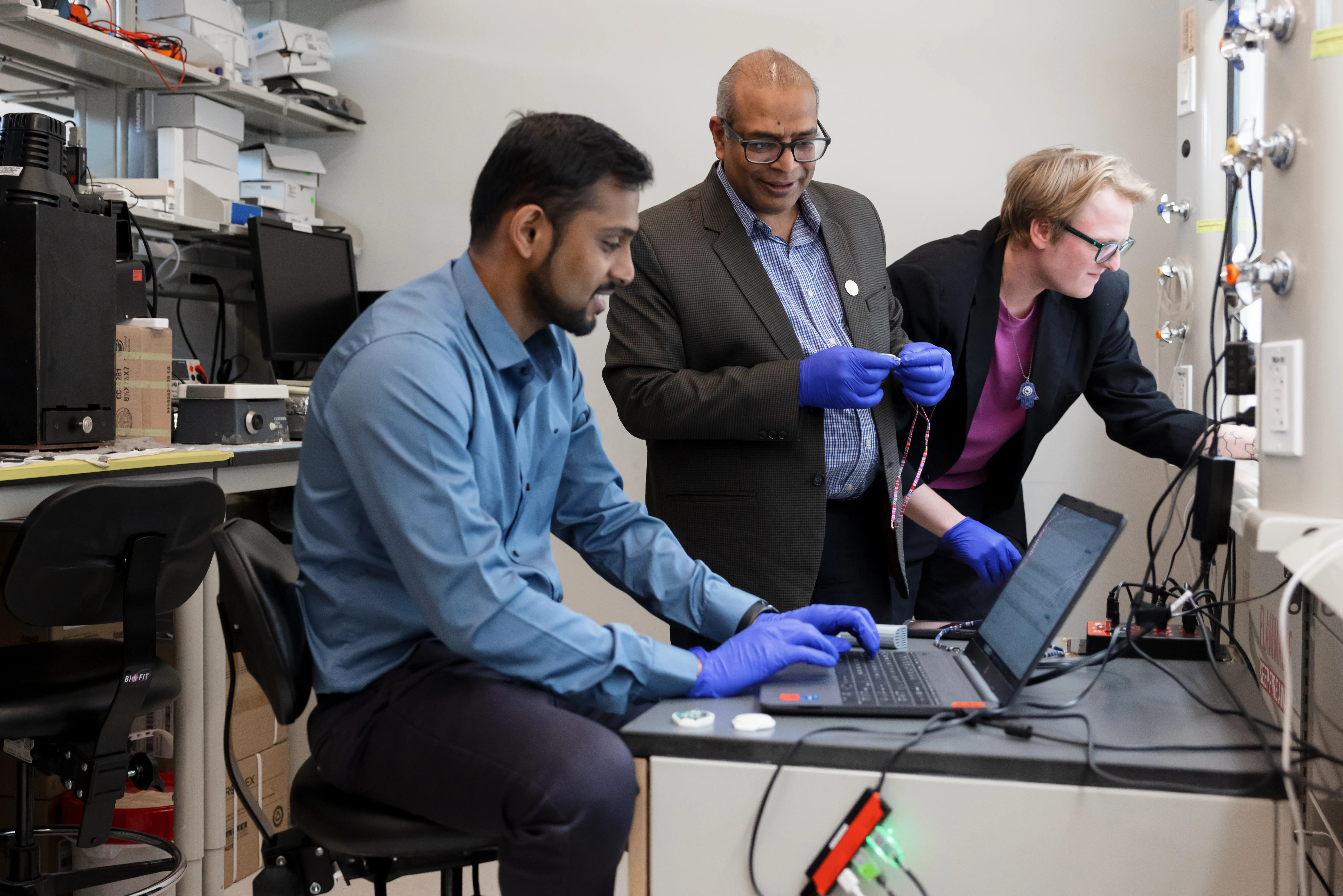 Research team reviewing data and conducting work in a laboratory setting.
