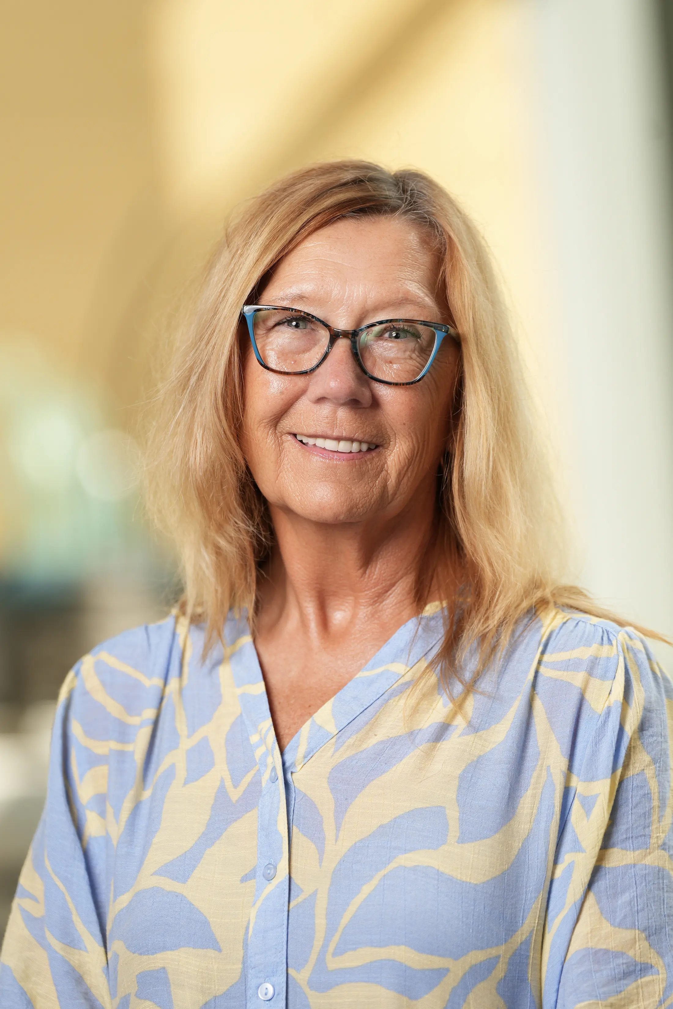A posed smiling woman looks directly at the camera.
