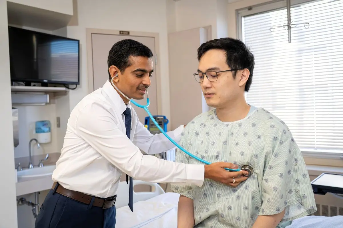 A doctor uses a stethoscope to listen to a patient's lungs.