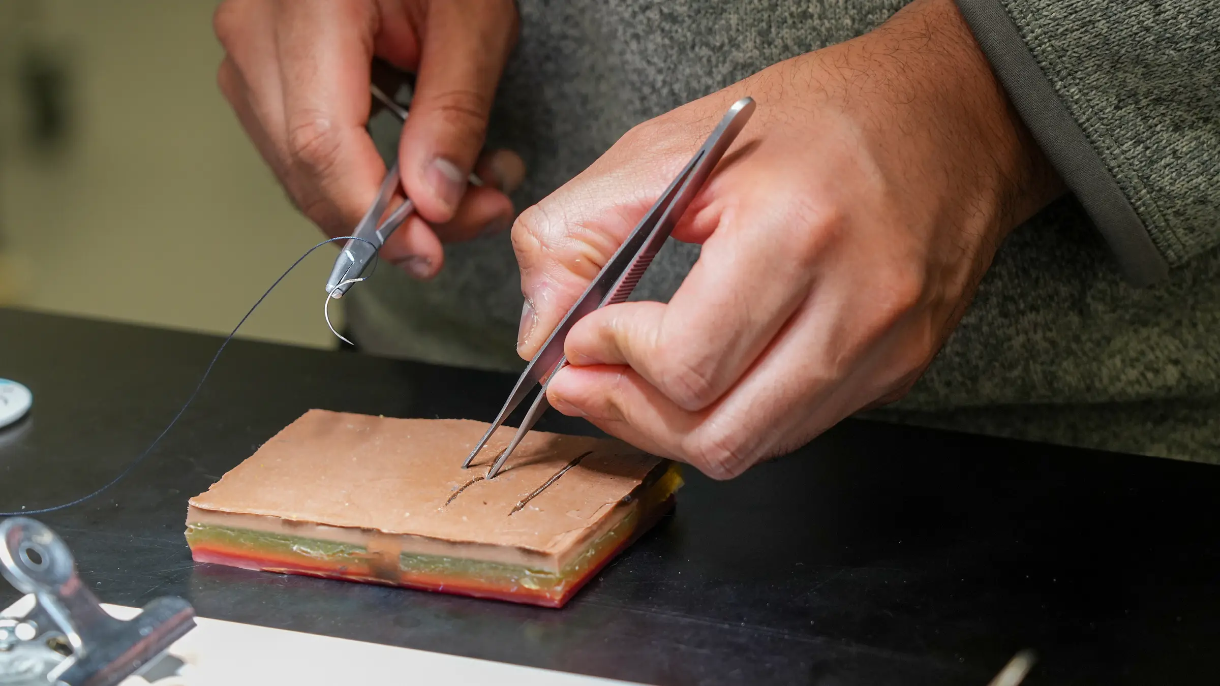 close up shot of hands practicing surgical skills