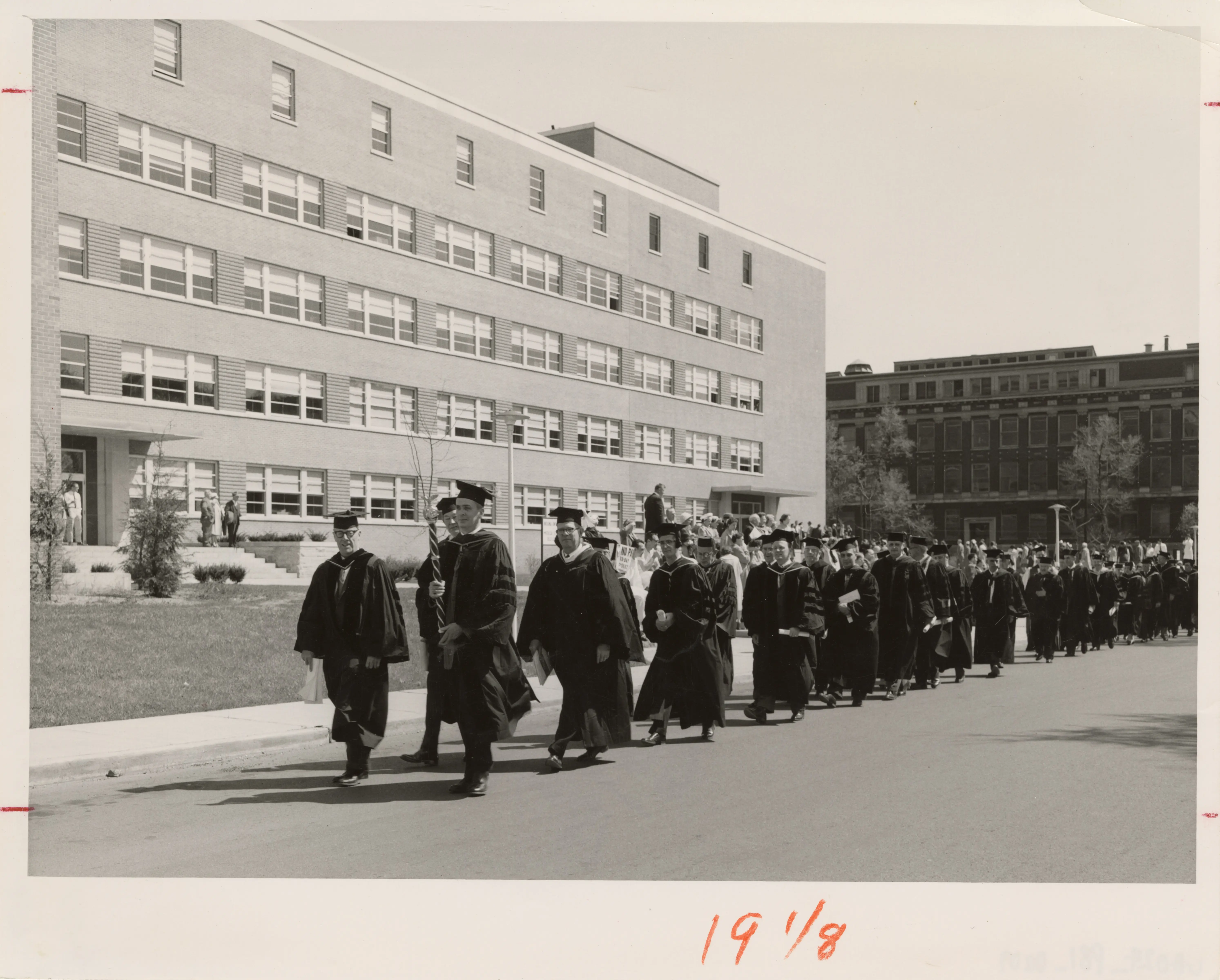 Black and White photo of people walking in front of a building