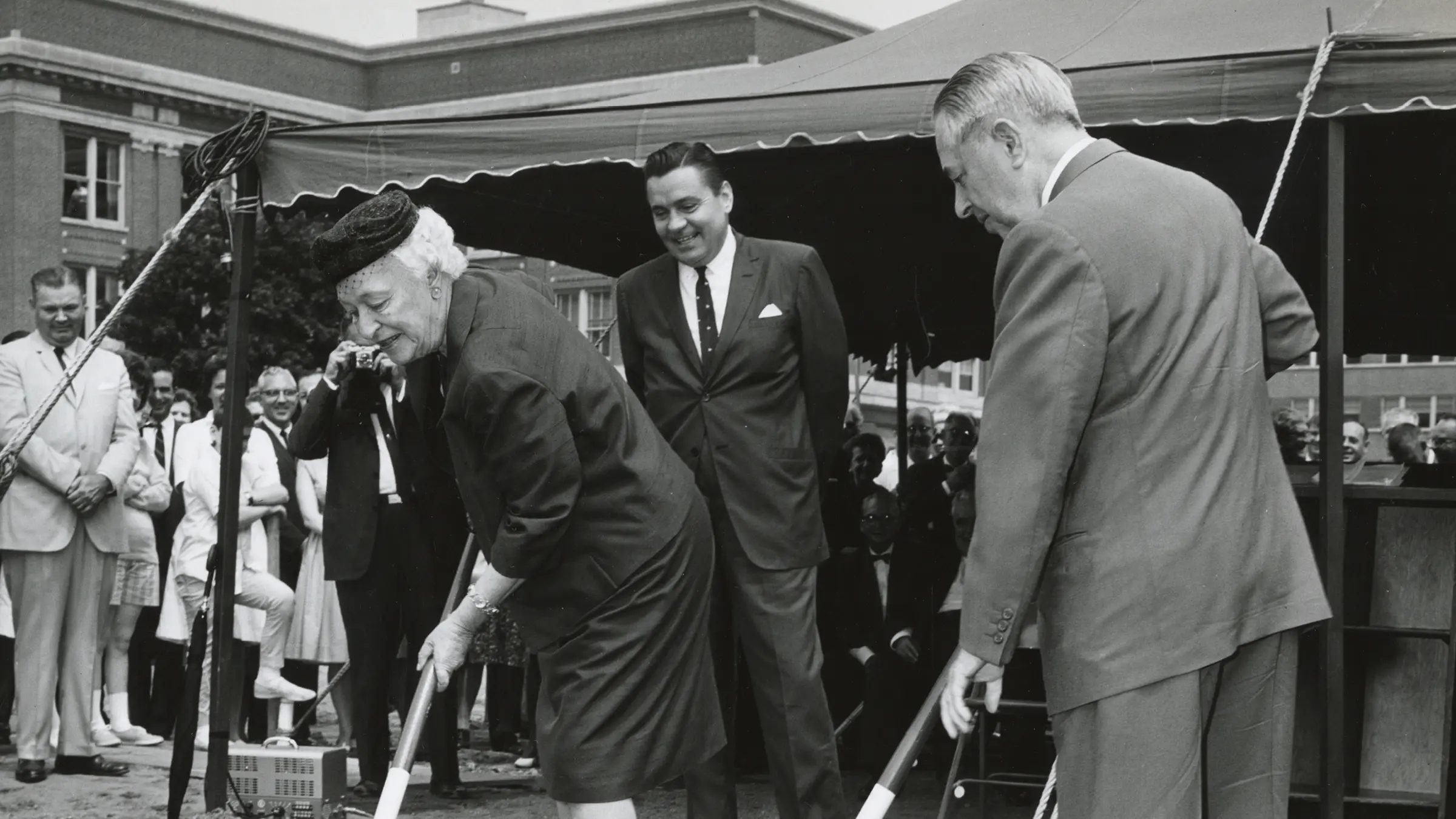 Black and White photo of people walking in front of a building