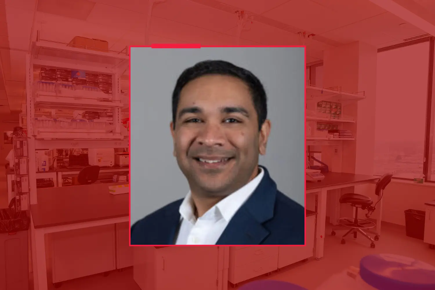 Headshot of Zainul Hasanali, against a red-toned background of a research lab.