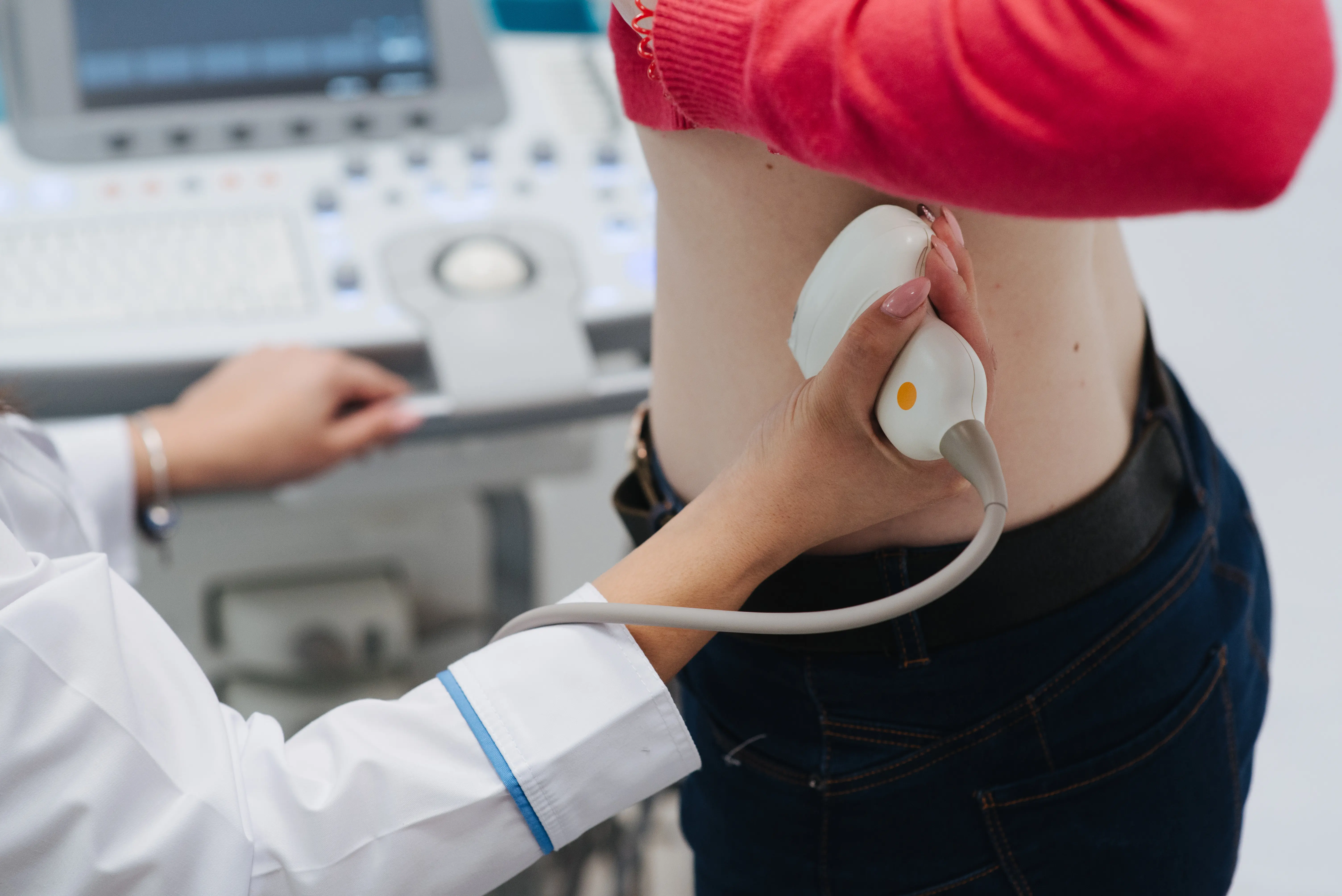 Ultrasound technician checking kidneys of patient