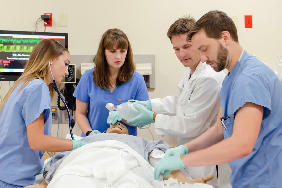 students work with a dummy in the clinical skills center