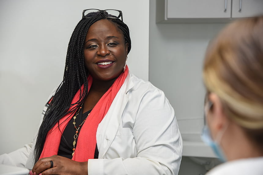 Dr. Oshinowo smiles as she speaks to a patient in the clinic