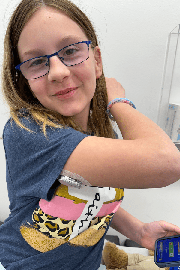 Emmaline Swigert shows off her continuous glucose monitoring system