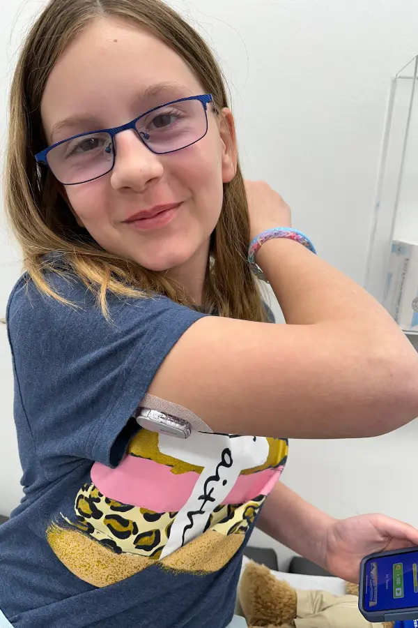 Emmaline Swigert shows off her continuous glucose monitoring system