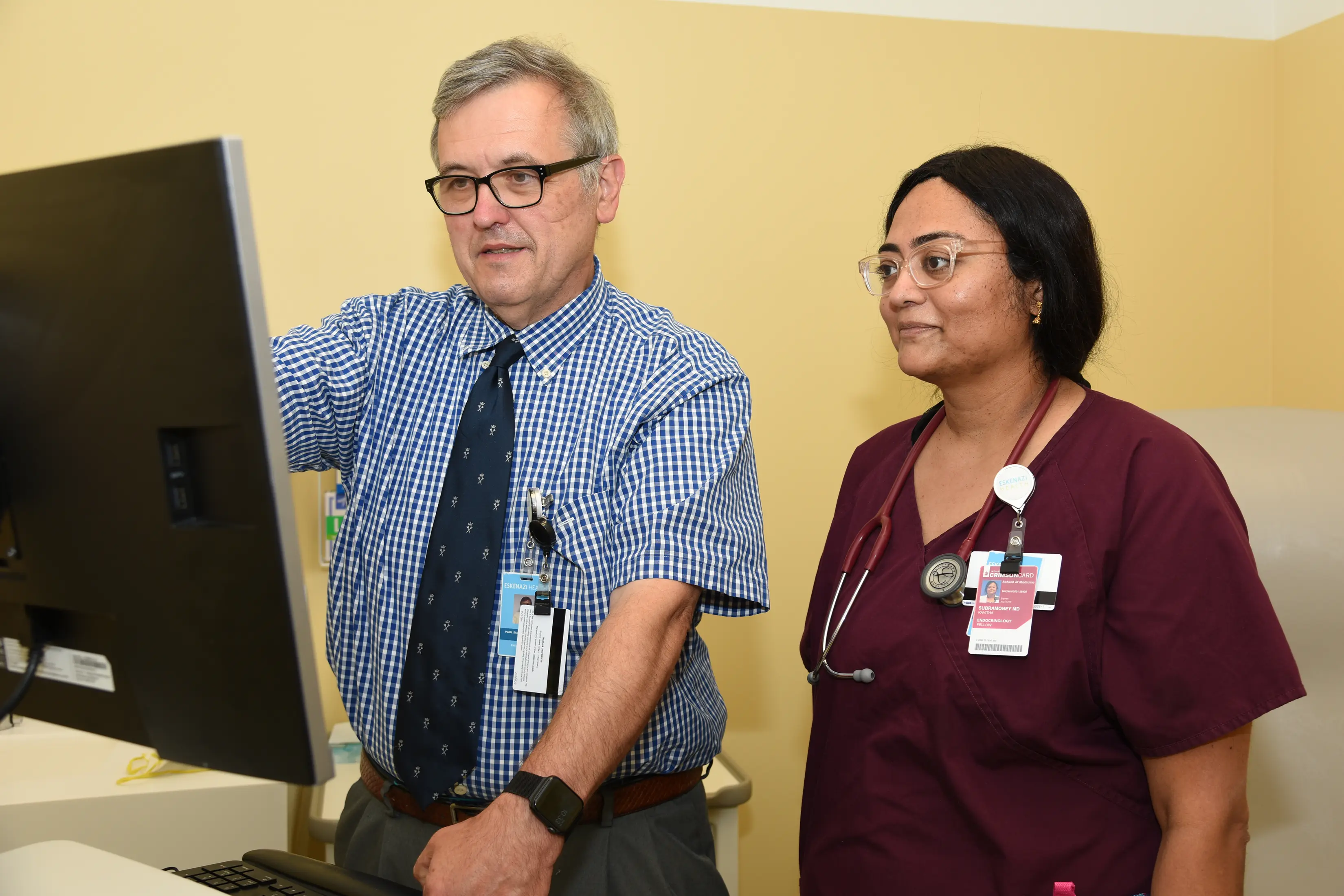 Two physicians review information on a monitor together