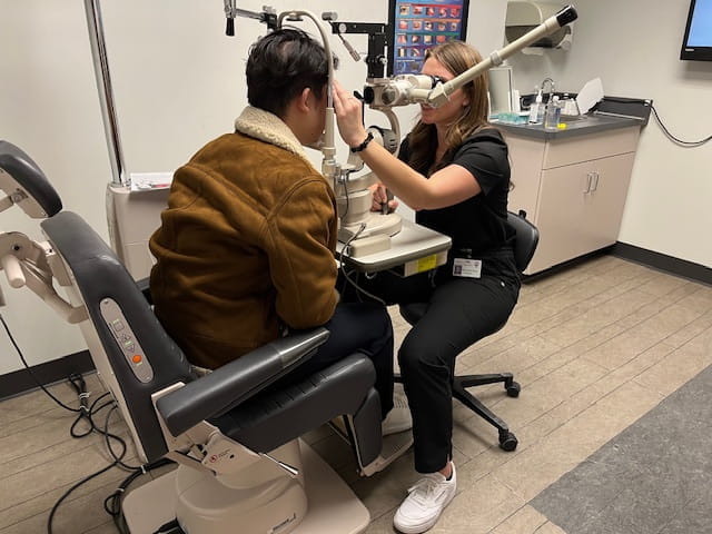 a physician examines a patient's eyes using ophthalmology equipment