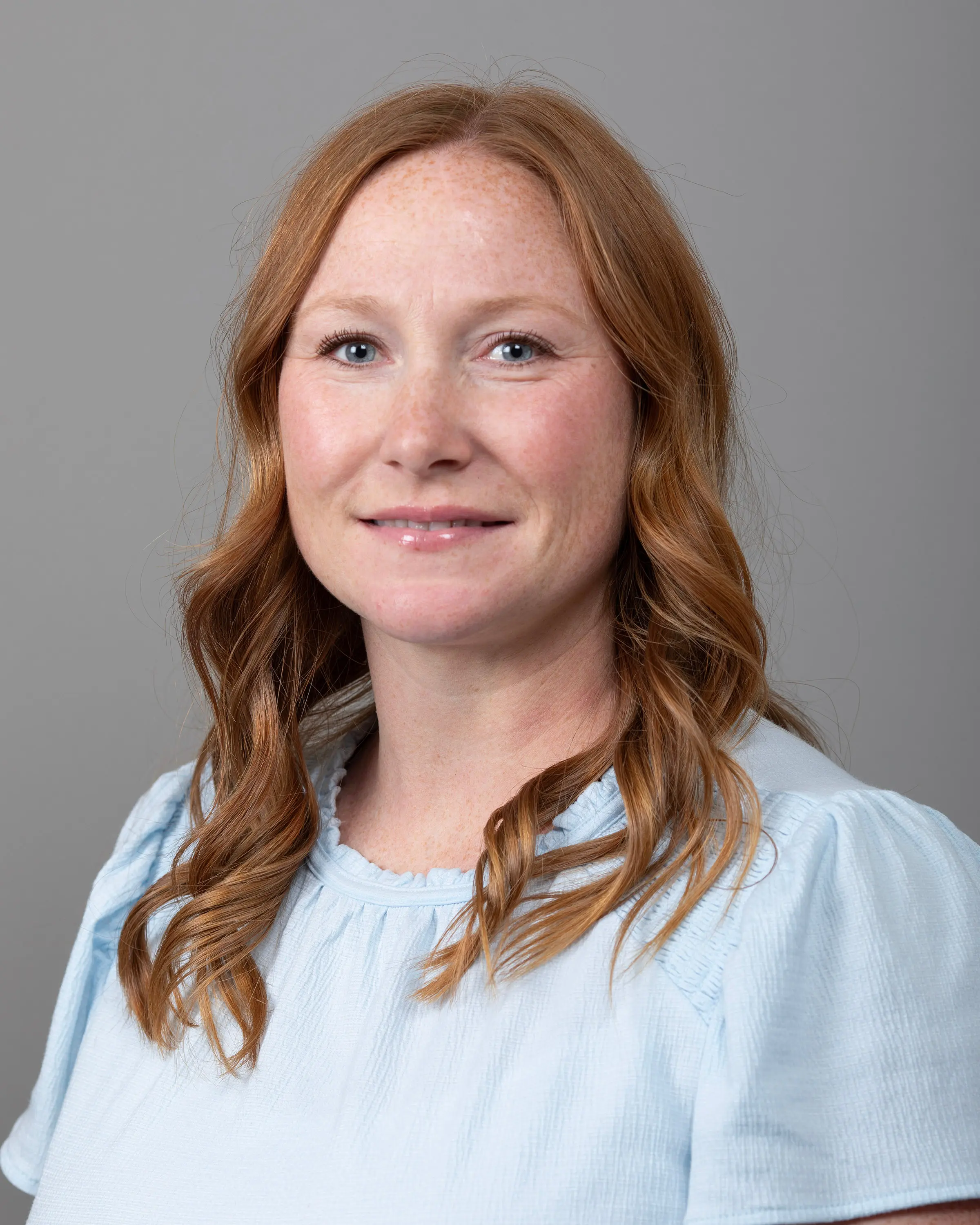 Person in professional attire smiling at camera