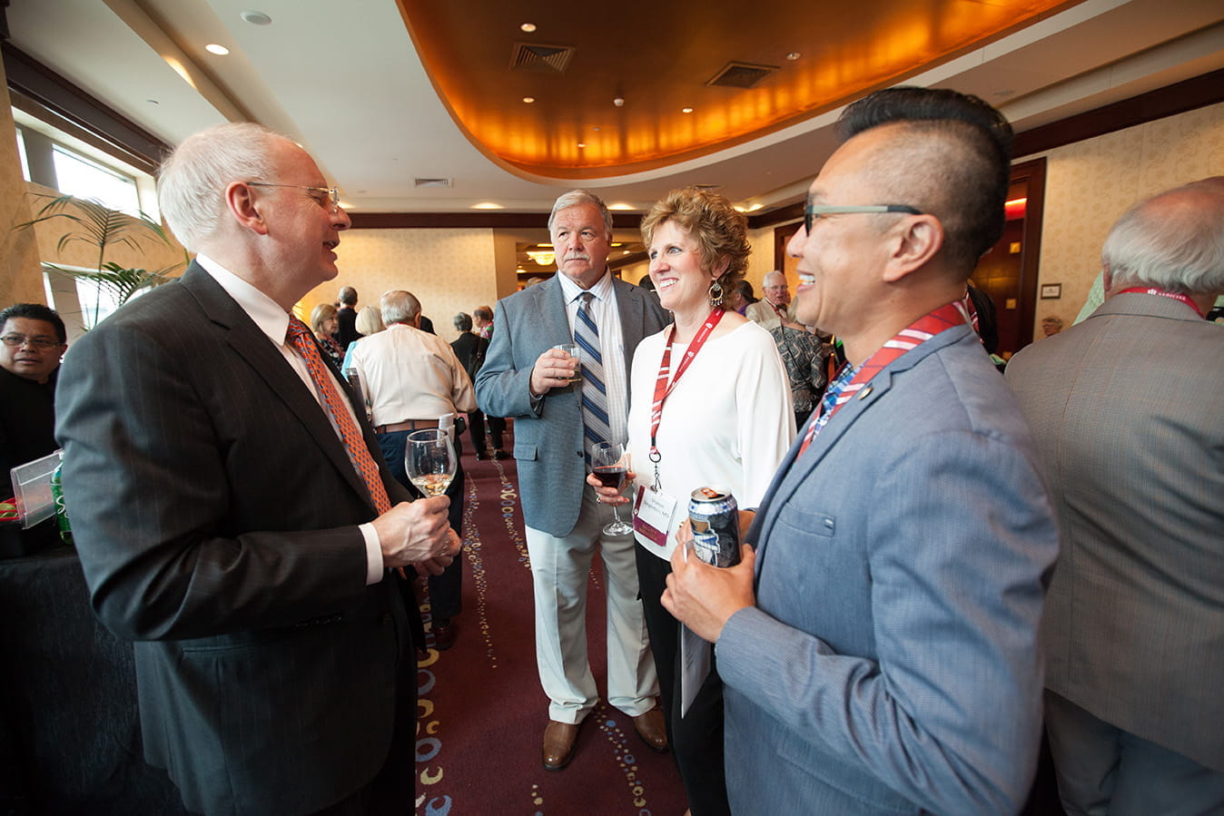 alumni at a reception talking and holding drinks