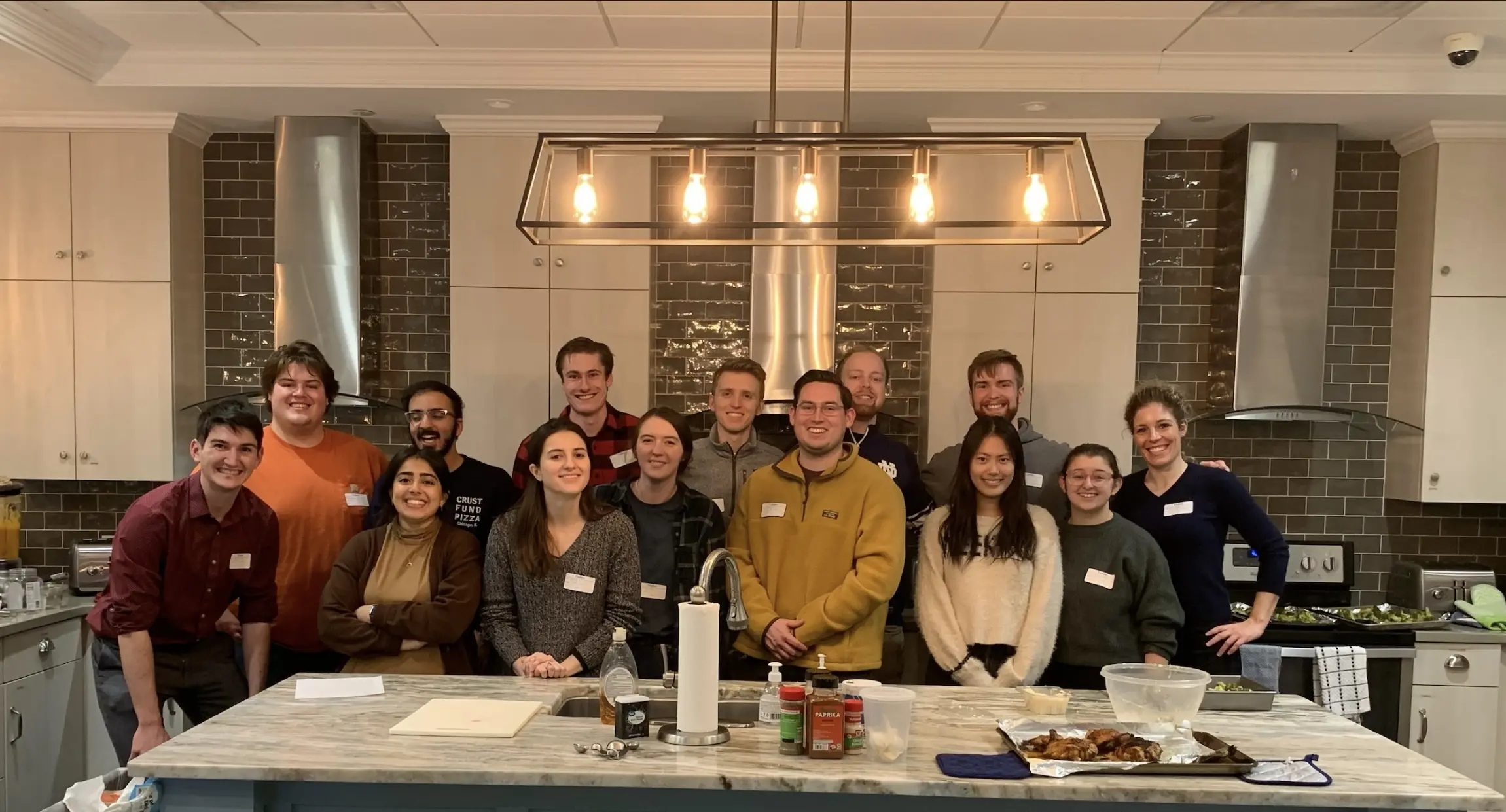 a group of trainees and faculty work in a kitchen at the ronald mcdonald house