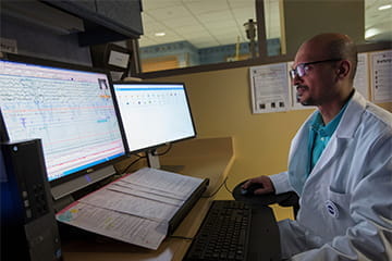 Researcher in sleep medicine looking at screens in the lab