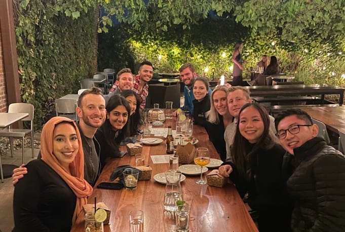 transitional year residents sit outside in a lit-up courtyard for a celebratory dinner