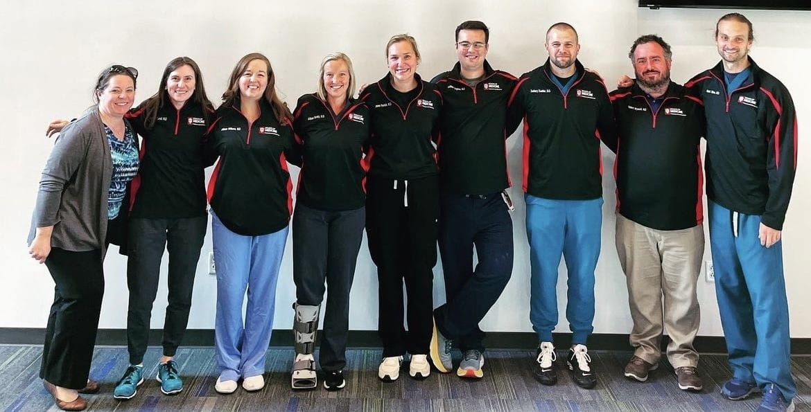 a group of fellows wearing matching black IU branded jackets