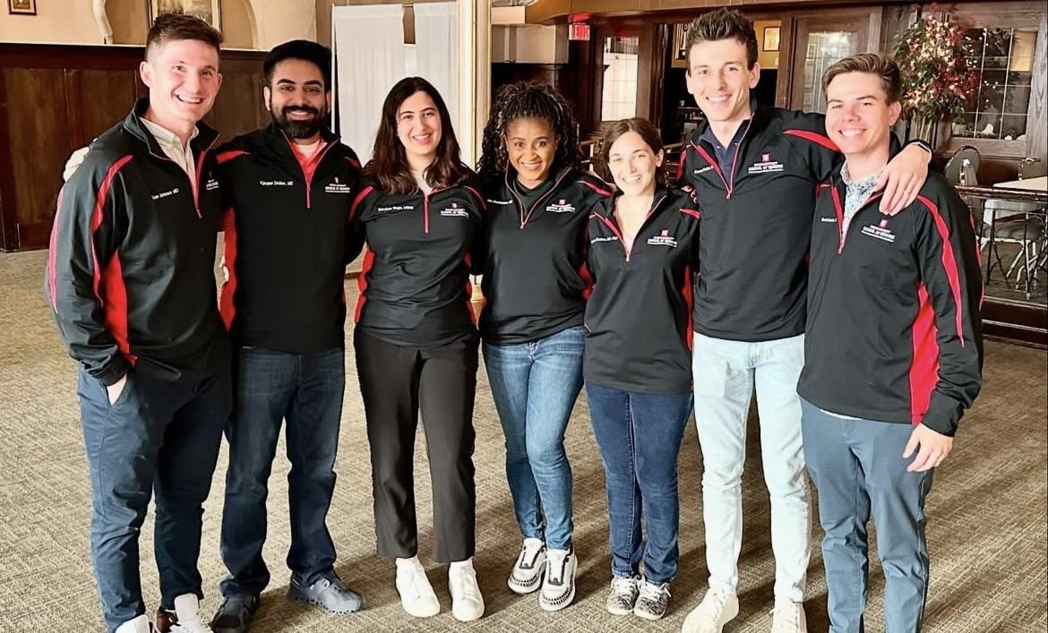 a group of fellows wearing matching black IU branded jackets