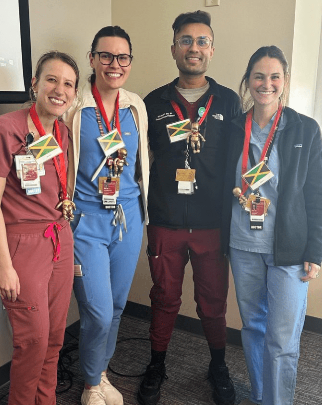 four residents in scrubs with their arms around each other