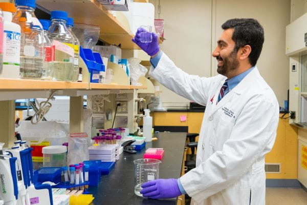 IU Surgery researcher takes a look at a beaker in the lab