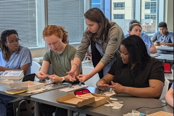 Payton Miller, MD, teaches medical students how to tie a suture