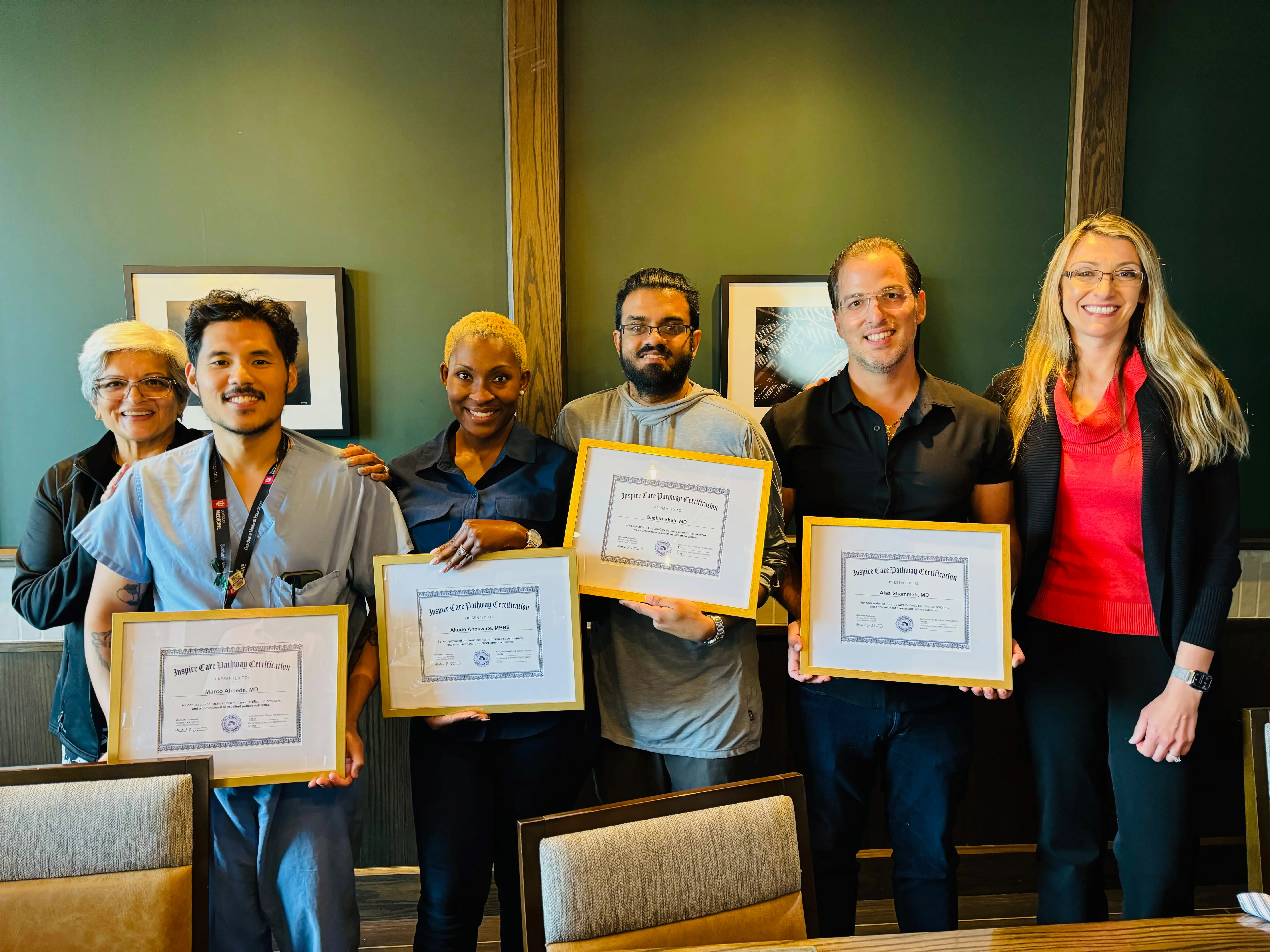 four Sleep Medicine fellows hold their graduation certificates and smile