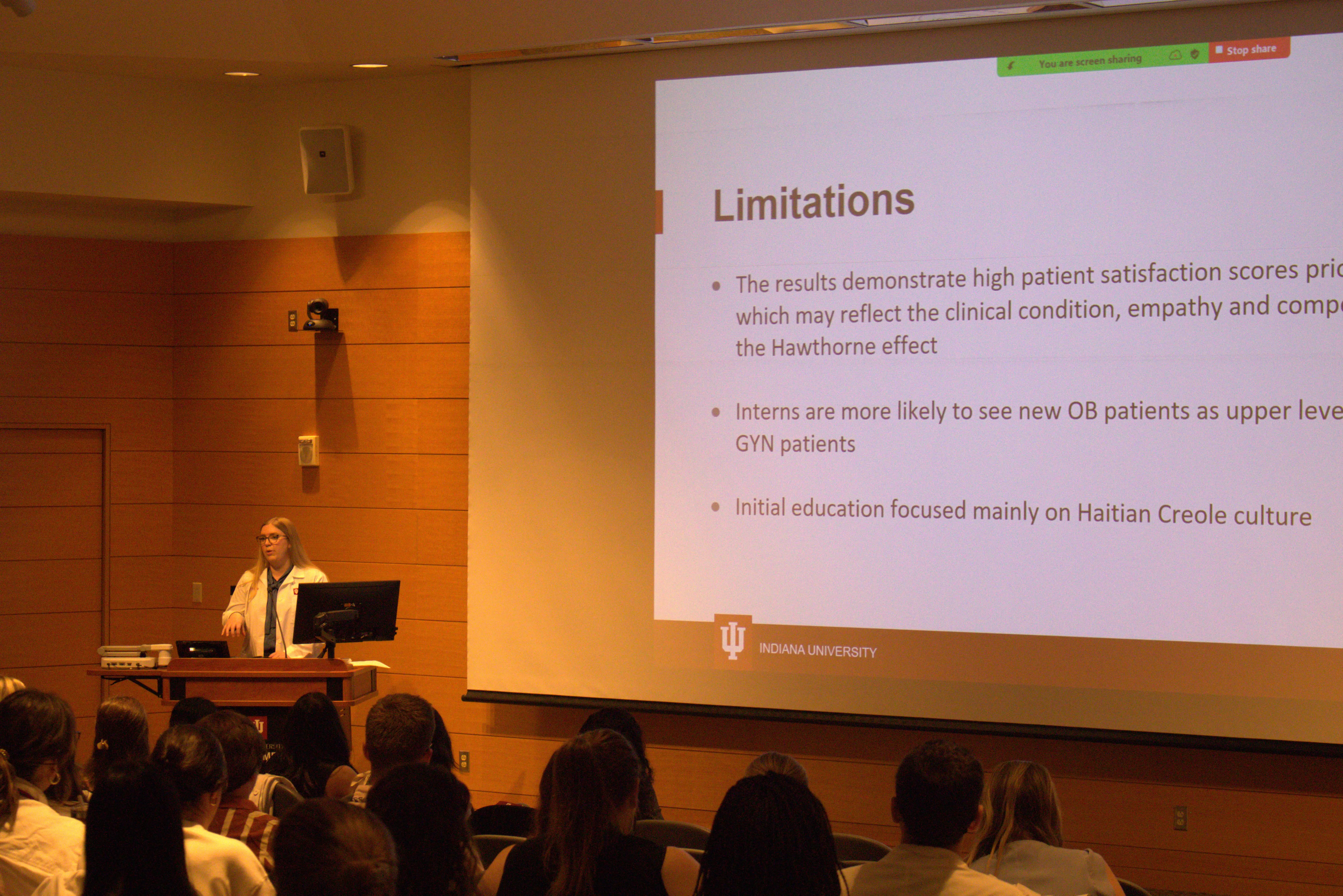 Dr. Katherine Wade stands at the lectern while presenting her research