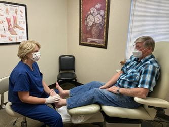 Podiatrist looks at patient who has a diabetic foot issue..