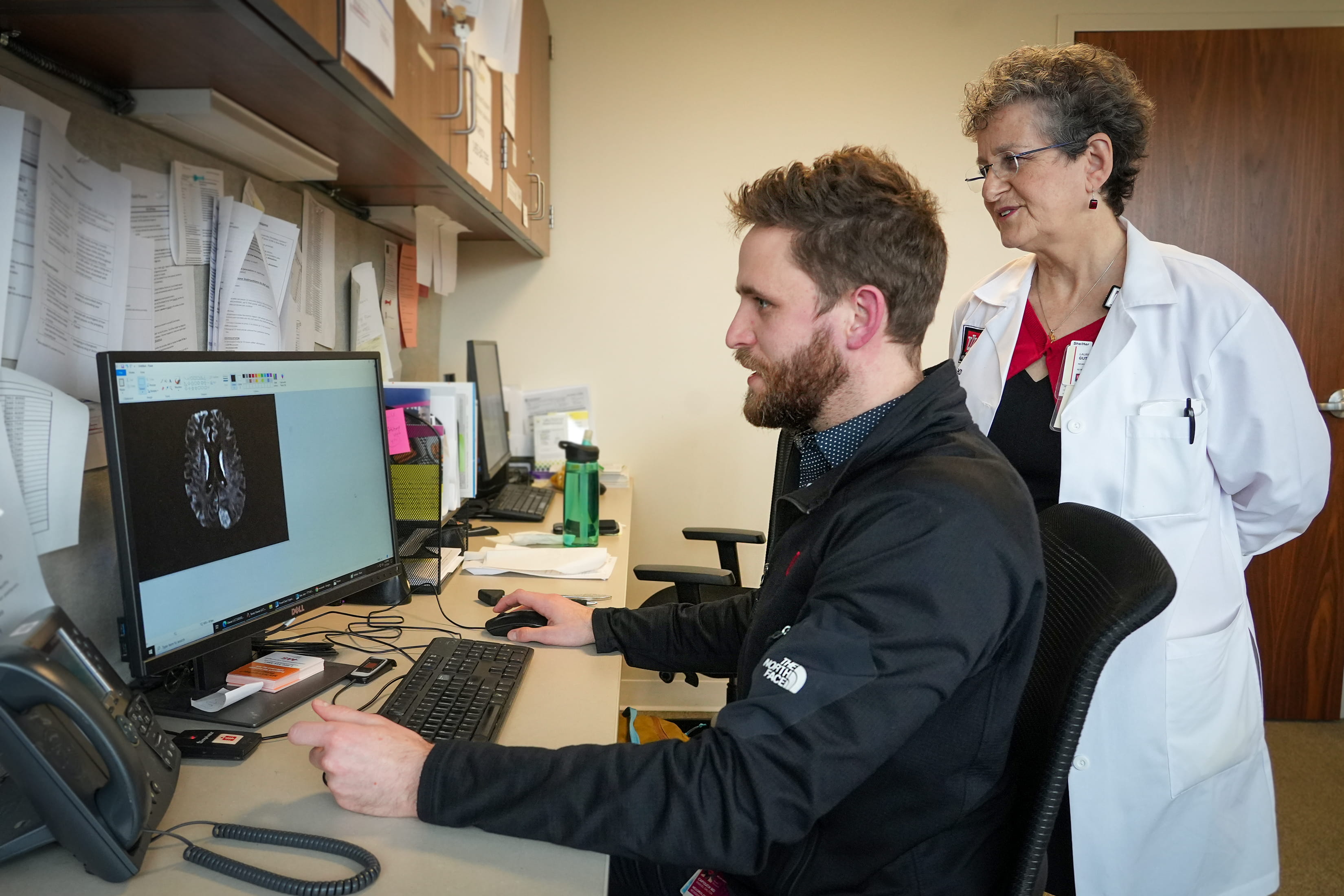 two neurologists review imaging scans together in a research office