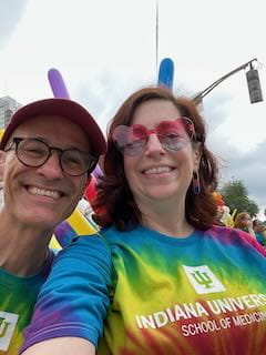 two iu faculty members smile and take a selfie at the pride parade