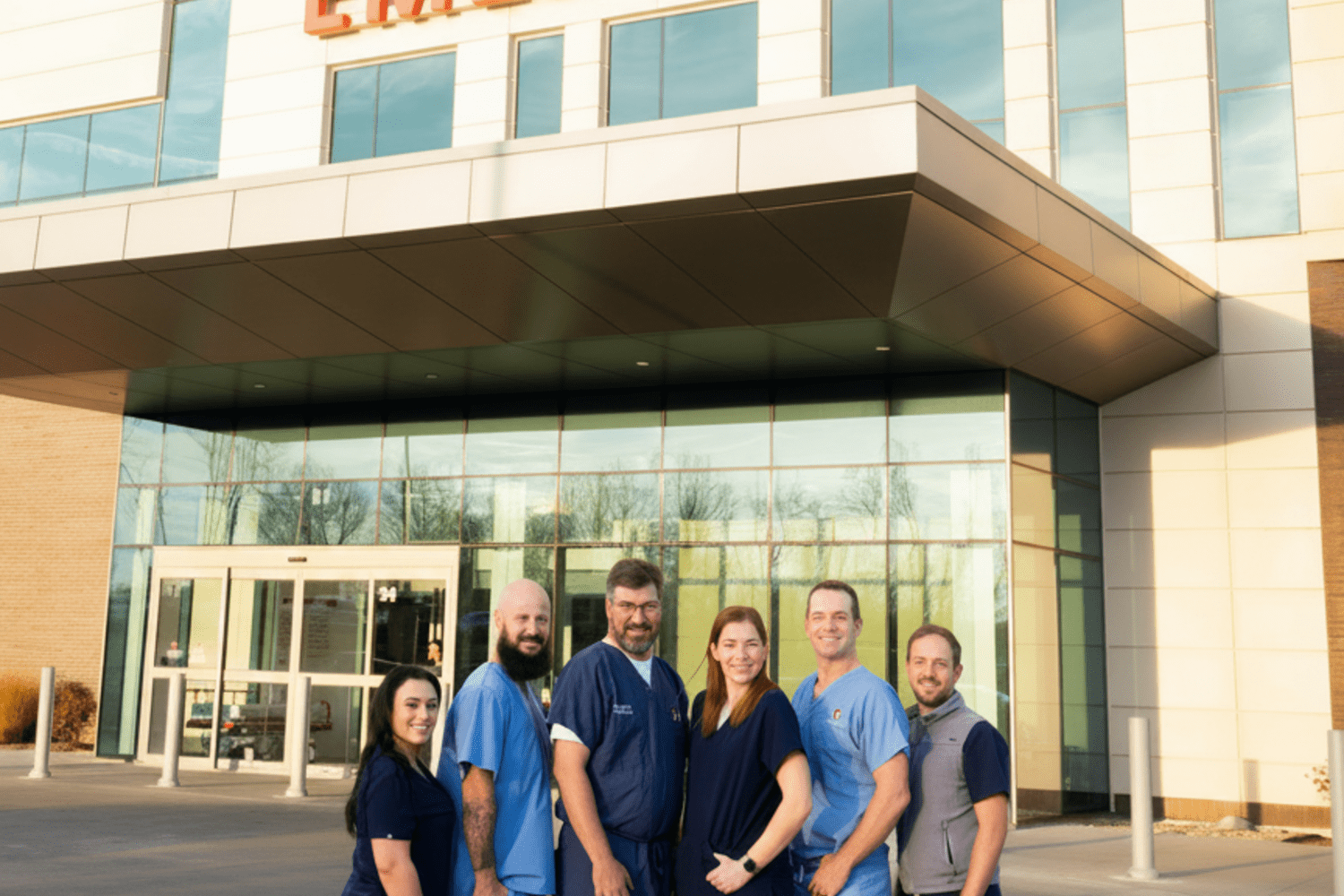 Six doctors standing in front of the Emergency Department doors 