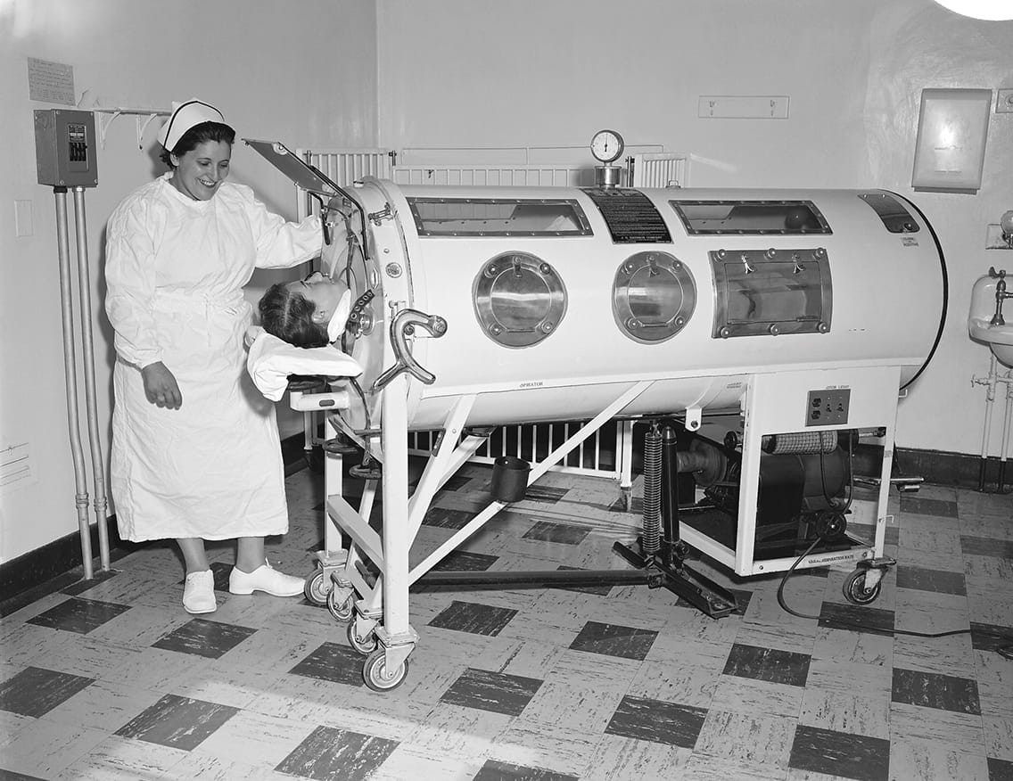 A child rests in an iron lung