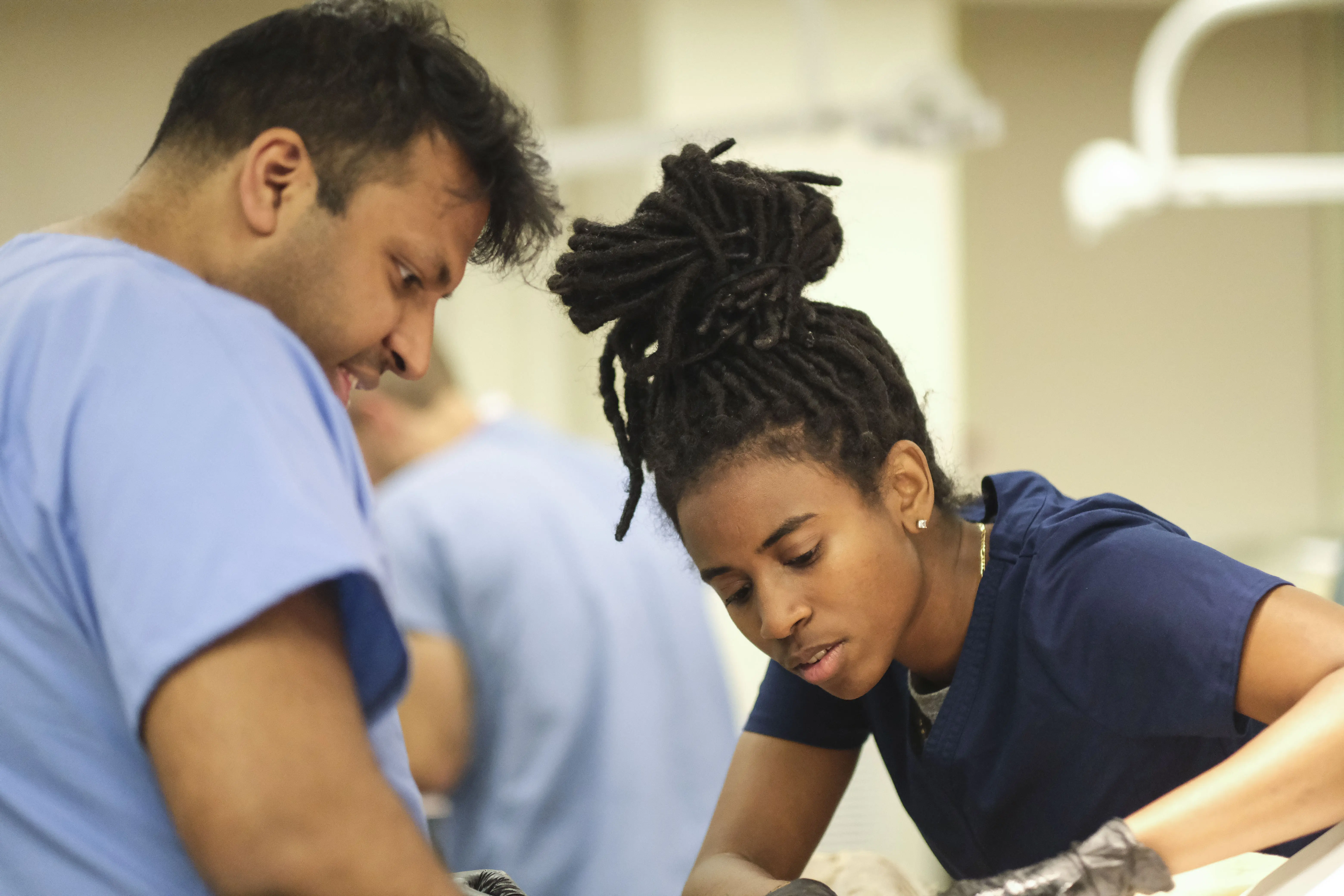 Medical students Taylor Smith and Chevy Singh consult each other during a dissection. 