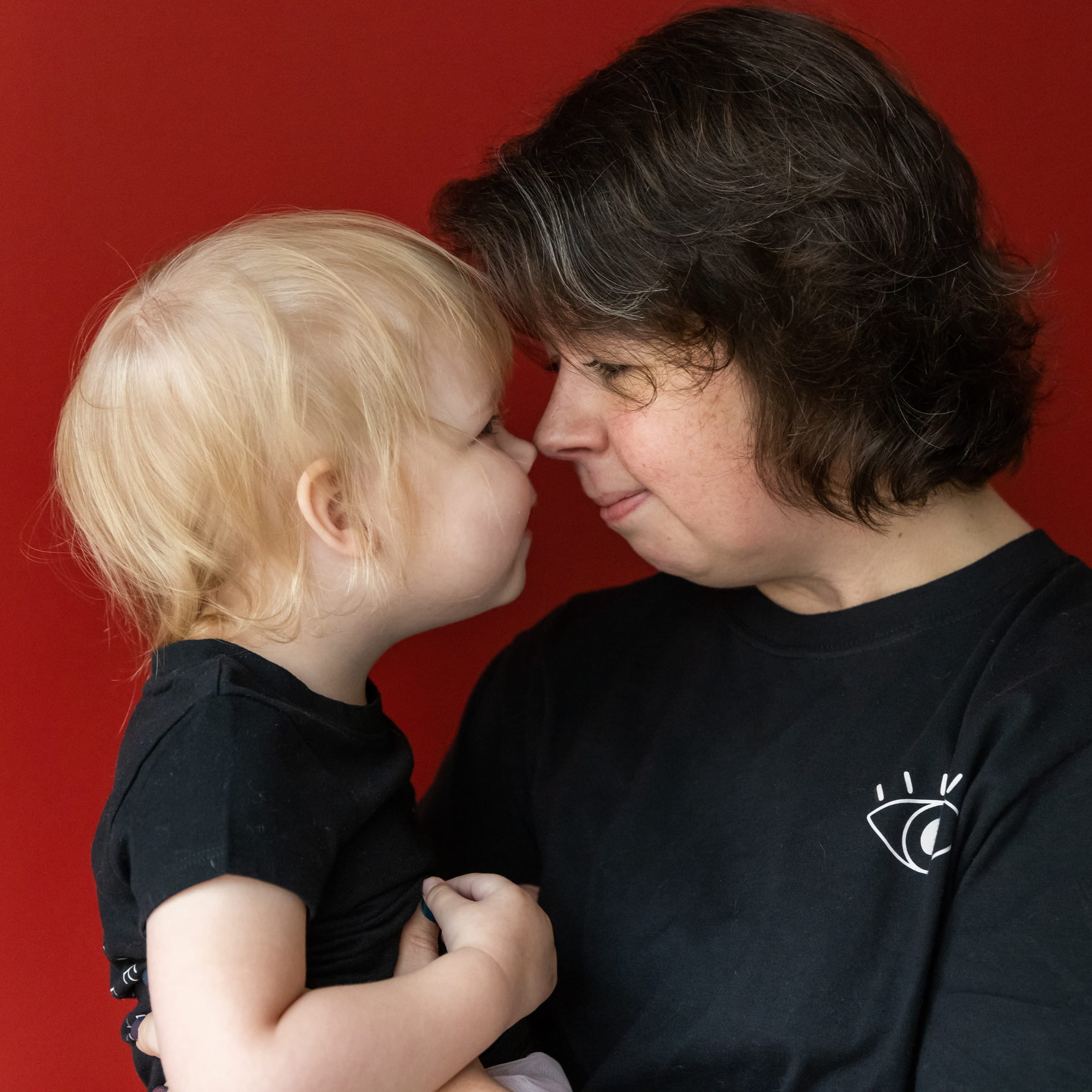 a mother and child look into each other's eyes