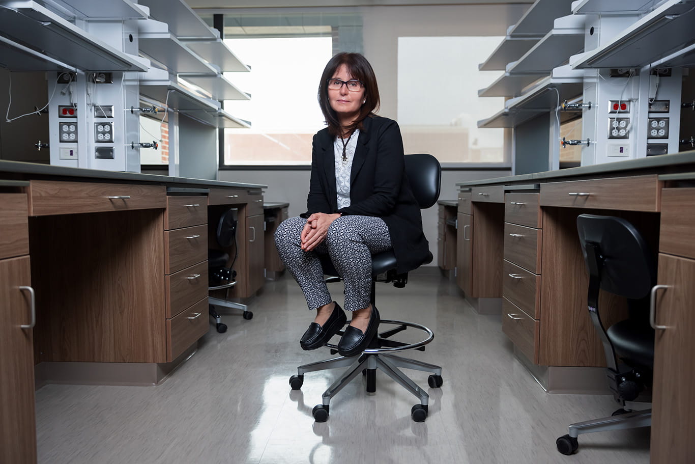 Huda Salman sits in the aisle of a lab space