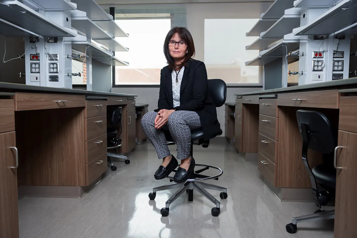 Huda Salman sits in the aisle of a lab space