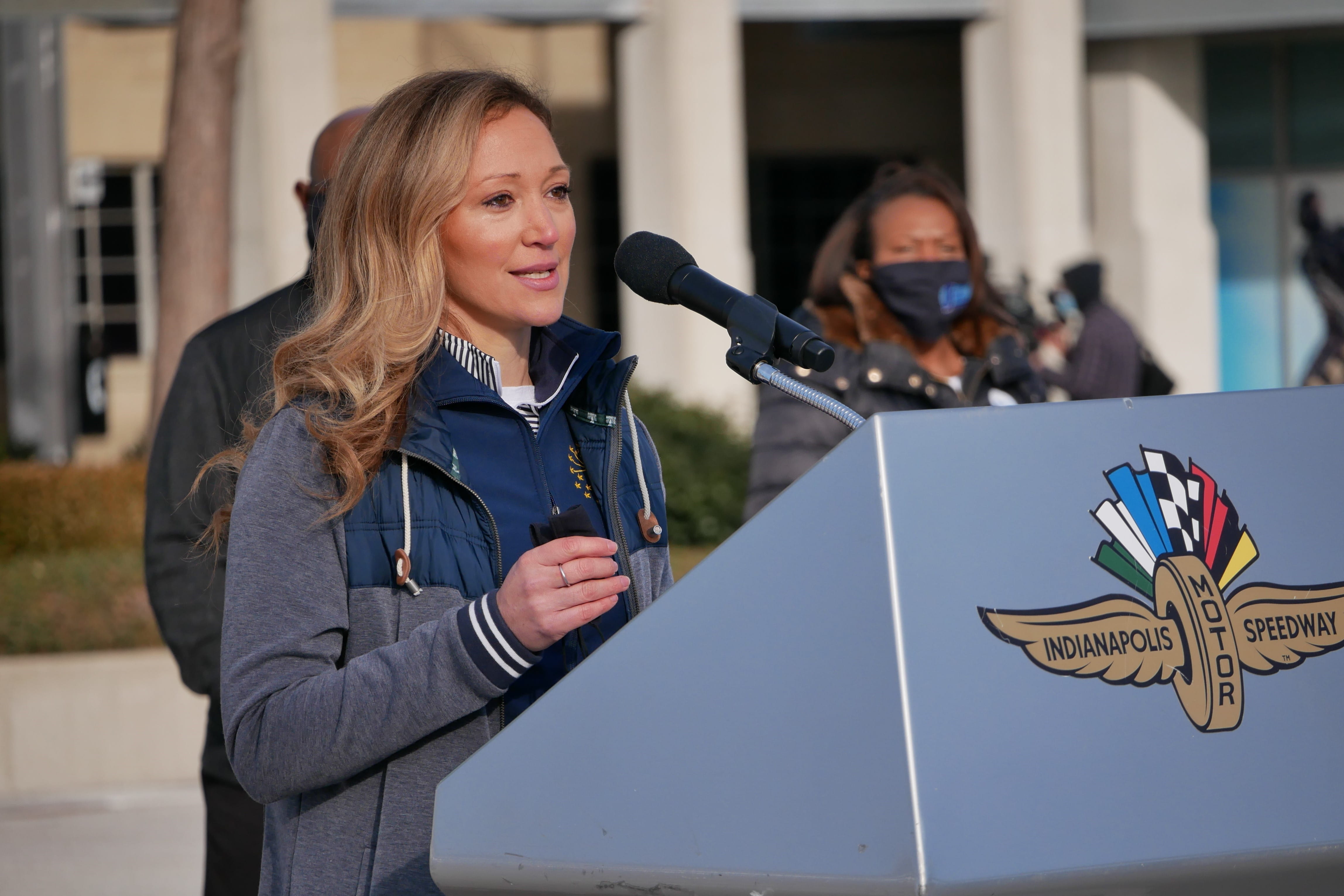 Lindsay Weaver speaks at a podium during a press conference during COVID