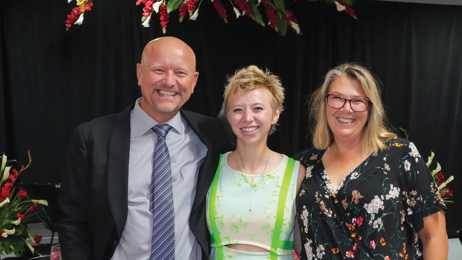Reagan Lessick and her parents at a formal celebration