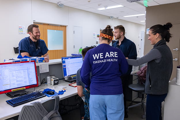 colleagues in the emergency department smile and chat during a break in a busy day.