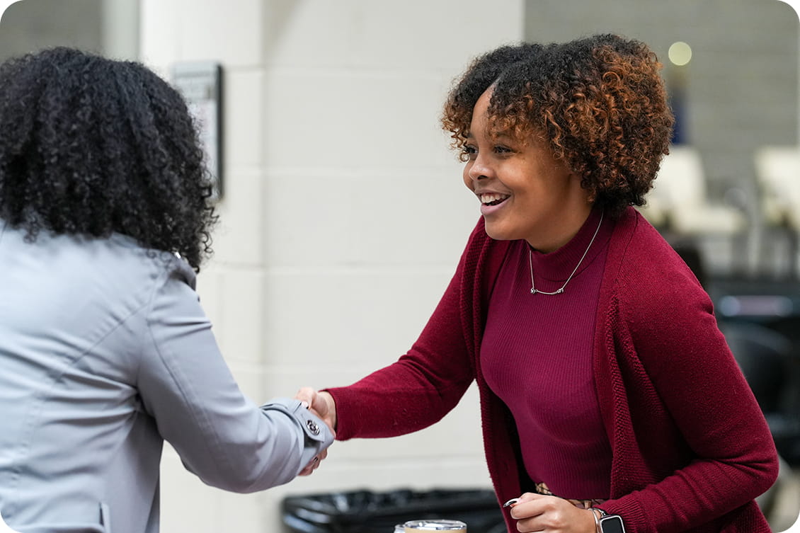 Kamille Ware shakes hands with a participant at a public health event