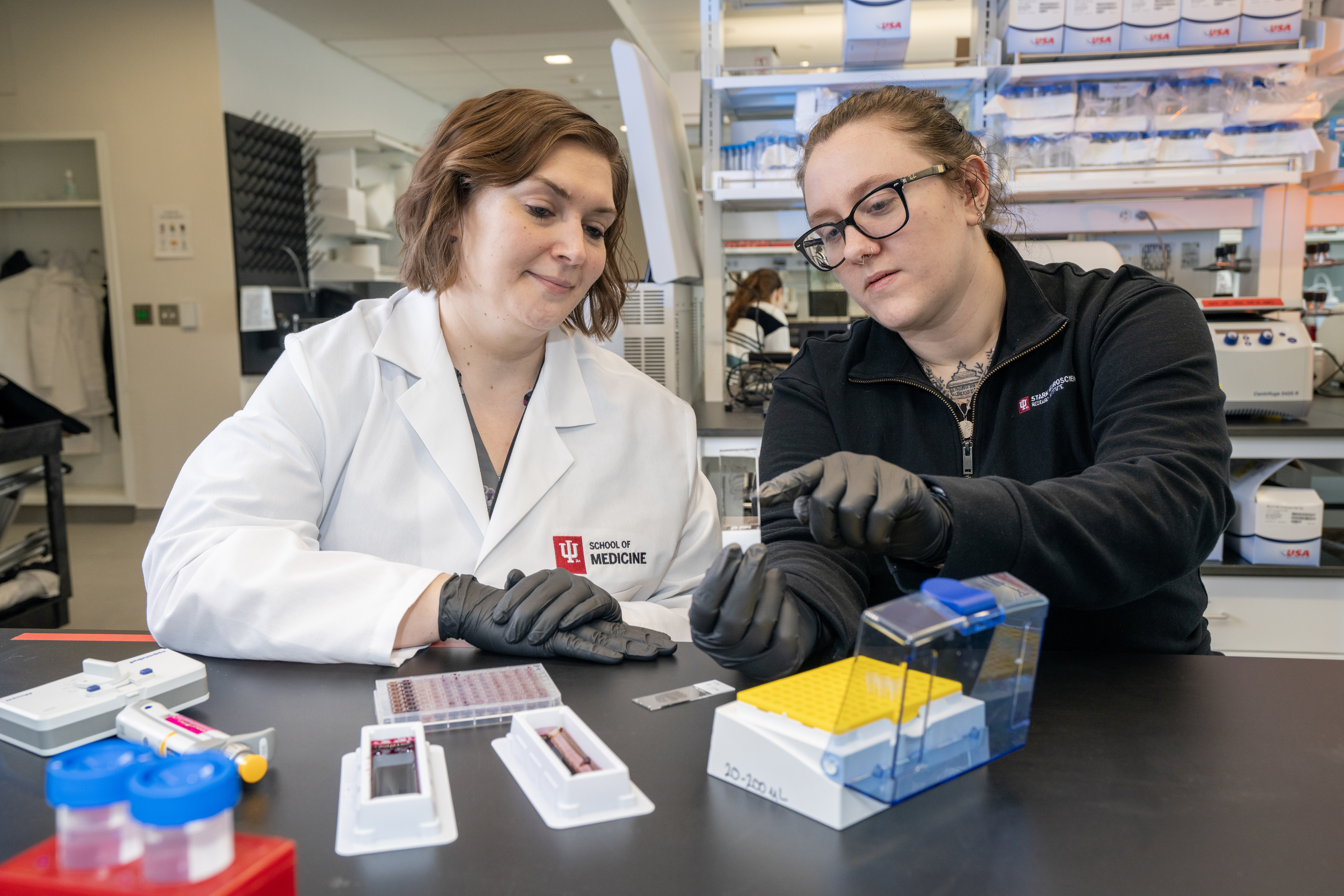 Erika Weekman and a student examine a slide sample in the lab