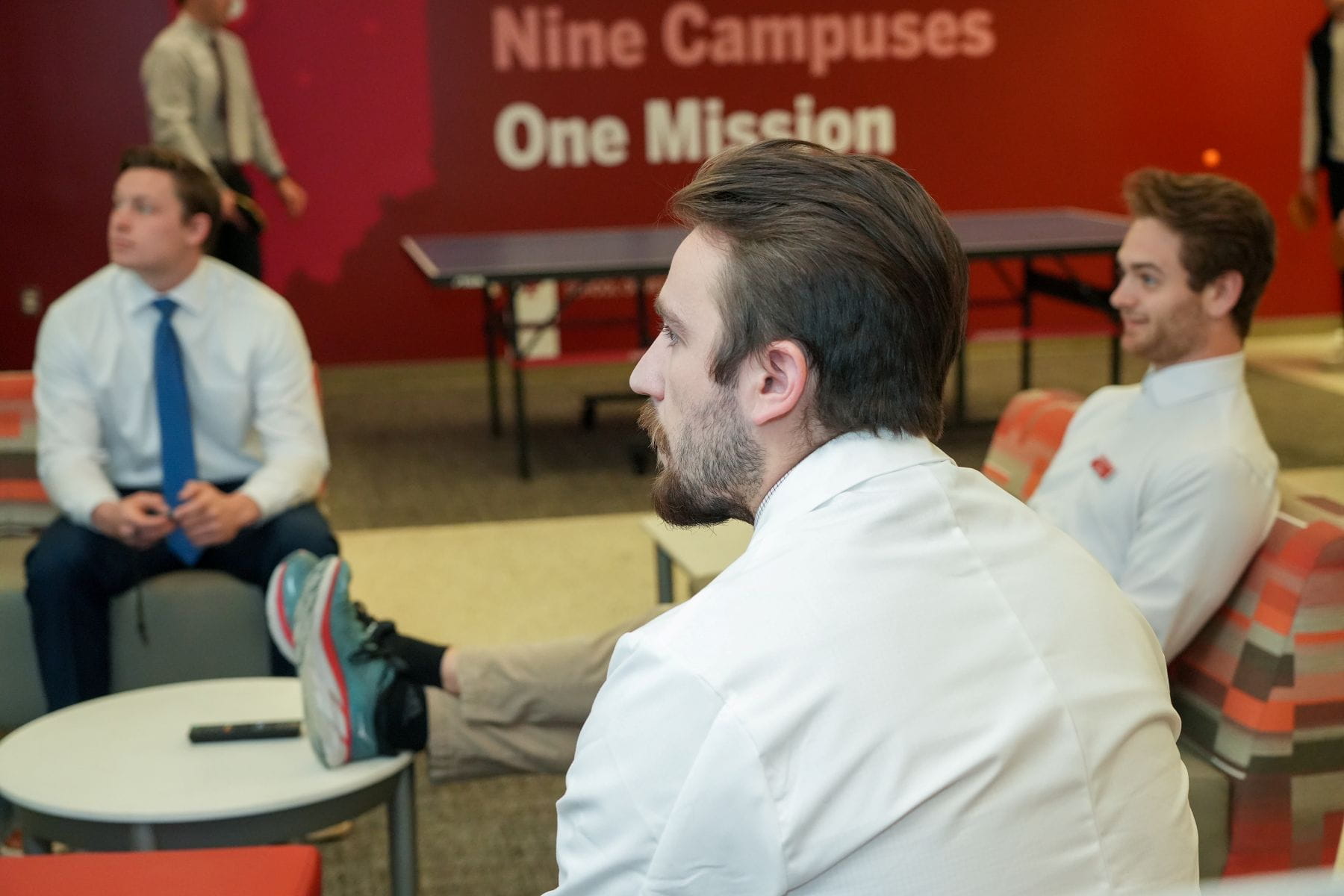 Three people sitting listening to someone else speaking