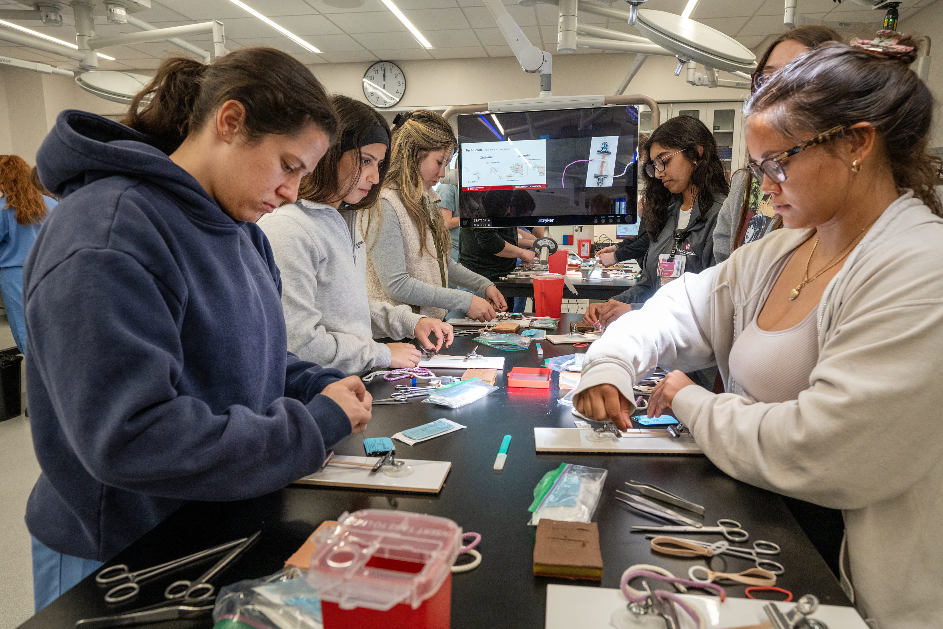 medical students work through knot-tying on simulated pads in the surgical skills center