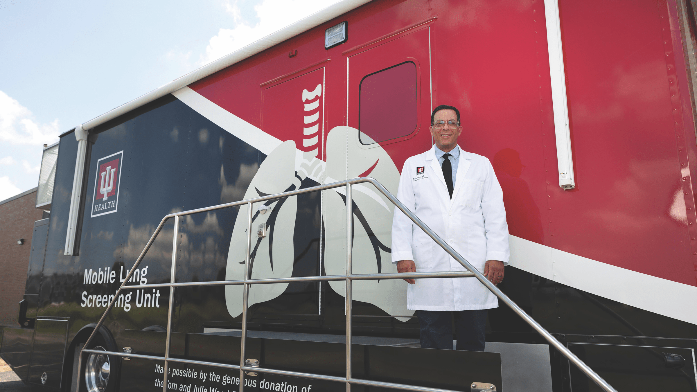 Cancer screening van with a person standing in front